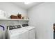 Bright laundry room with white washer and dryer, and ample shelving for storage at 10 Colony Ridge Dr, Alpharetta, GA 30022