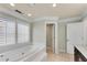 Bright bathroom features a soaking tub next to a large window and a door to the walk in closet at 1029 Fairway Ne Ests, Atlanta, GA 30319