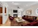 Spacious living room with fireplace, hardwood floors, and a red color palette with a ceiling fan at 1029 Fairway Ne Ests, Atlanta, GA 30319