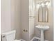 Small half bathroom featuring a pedestal sink, gold fixtures, and decorative mirror at 2515 Oak Quarters, Smyrna, GA 30080