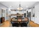 Dining area with an ornate chandelier, wood table, and seating, adjacent to the kitchen at 4620 Westgate Dr, Cumming, GA 30040