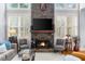 Close up of a stone fireplace, hardwood floors, and large windows that offer ample natural light at 4620 Westgate Dr, Cumming, GA 30040