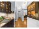 Hallway with a bar area, featuring dark wood cabinets, granite countertops, and views into the dining area at 4620 Westgate Dr, Cumming, GA 30040