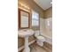 Well-lit bathroom featuring a pedestal sink, toilet, and tub with shower at 1027 Holland Rd, Dallas, GA 30157