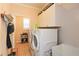 Well-lit laundry room with white cabinets, washer, dryer, and folding area at 422 Windy Ridge Way, Canton, GA 30114