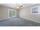 Bedroom features a ceiling fan, new carpet, and doors to the backyard patio at 1618 Cheryl Leigh Dr, Riverdale, GA 30296