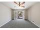 This bedroom features neutral paint, a ceiling fan, carpet floors, and french doors that lead to an outdoor space at 1618 Cheryl Leigh Dr, Riverdale, GA 30296