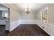 Cozy dining room featuring classic wainscoting, chandelier, and hardwood floors at 1618 Cheryl Leigh Dr, Riverdale, GA 30296