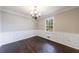 Dining area with wainscoting, neutral paint, hardwood floors, and chandelier at 1618 Cheryl Leigh Dr, Riverdale, GA 30296