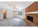 Cozy living room featuring a brick fireplace, ceiling fan, and a bright window at 1618 Cheryl Leigh Dr, Riverdale, GA 30296