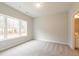 Well-lit bedroom with neutral carpet, a large window, and ensuite bathroom access at 4826 Floydwood Ln, Mableton, GA 30126