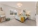 Bright bedroom with a cream bed frame, yellow throw blanket, and matching end table lamps at 4826 Floydwood Ln, Mableton, GA 30126