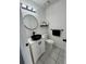 Chic powder room featuring a round mirror, sleek black sink, and a floating shelf at 5055 Promenade Sw Dr, Atlanta, GA 30331