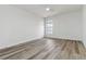 Minimalist bedroom with wood look flooring, a window, and plain white walls at 5729 Evadale Trce # 6, Mableton, GA 30126