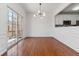 Bright dining room with hardwood floors, wainscoting, modern light fixture, and sliding glass doors to the balcony at 5729 Evadale Trce # 6, Mableton, GA 30126