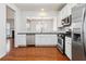 Open kitchen showcasing stainless steel appliances, white cabinets, dark countertops, and a view to the dining room at 5729 Evadale Trce # 6, Mableton, GA 30126