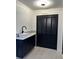 Bright and stylish laundry room featuring a modern sink, quartz countertop, and dark wood accents at 2087 Blackberry Ln, Auburn, GA 30011