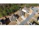 An aerial view shows the backyard, and surrounding neighborhood in a residential area with mature trees and manicured lawns at 784 Sunset Down Ct, Loganville, GA 30052