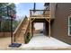 View of the home's backyard featuring a two-tiered deck with a basketball hoop, and string lights underneath at 784 Sunset Down Ct, Loganville, GA 30052