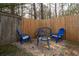 Cozy backyard seating area with chairs and a table, surrounded by a wooden fence and gravel at 784 Sunset Down Ct, Loganville, GA 30052