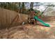 Wooden playset in the backyard with swings and slide provides a fun play area for children at 784 Sunset Down Ct, Loganville, GA 30052