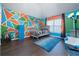 bedroom with blue rug, a Batman statue, and geometric accent wall at 784 Sunset Down Ct, Loganville, GA 30052
