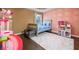 Bright bedroom with a dollhouse, pink slide, and unique pink-and-gold wallpaper at 784 Sunset Down Ct, Loganville, GA 30052