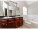 Bathroom features a double sink vanity with a large tub and tile surround at 1935 Cutters Mill Way, Lithonia, GA 30058