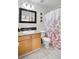 Bright bathroom featuring a granite countertop, neutral tile, and floral shower curtain at 6730 Gallant Se Ct, Mableton, GA 30126