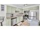 Well-lit kitchen features stainless steel appliances, granite countertops, and muted green cabinetry at 6730 Gallant Se Ct, Mableton, GA 30126