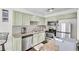 Charming kitchen featuring stainless steel appliances, granite countertops, and sage-green cabinets at 6730 Gallant Se Ct, Mableton, GA 30126