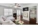 Open living room with a fireplace, sofa, ceiling fan, and a view of the backyard at 6730 Gallant Se Ct, Mableton, GA 30126