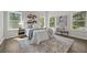 Well-lit main bedroom with hardwood floors, three windows, and tasteful decorations at 6971 Tan Bark Ct, Riverdale, GA 30296