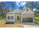 Charming single-Gathering home featuring stone accents, attached garage, and welcoming entrance at 6971 Tan Bark Ct, Riverdale, GA 30296