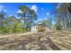 Exterior of the home shows a cleared backyard and a charming covered deck at 6971 Tan Bark Ct, Riverdale, GA 30296