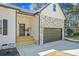 Inviting front entrance features a two-car attached garage and stylish stone detailing at 6971 Tan Bark Ct, Riverdale, GA 30296
