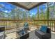 Covered patio features wood decking, outdoor furniture, and a view of the wooded backyard at 6971 Tan Bark Ct, Riverdale, GA 30296