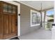View of front porch with a hanging hammock chair and wooden front door at 733 Rice Nw St, Atlanta, GA 30318