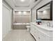 Elegant bathroom featuring a soaking tub, tiled walls, dual sinks, vanity, and a clean, modern design at 1406 Kennesaw Nw Dr, Atlanta, GA 30318