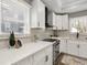 Close up of the updated kitchen showcasing quartz countertops, stainless steel appliances and white cabinetry at 1406 Kennesaw Nw Dr, Atlanta, GA 30318