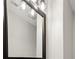 Close-up of a bathroom mirror with a black frame and unique, geometric light fixtures, adding a modern touch at 1406 Kennesaw Nw Dr, Atlanta, GA 30318