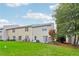 Large backyard with well-manicured lawn, mature trees, and neighboring townhomes at 1624 River Main Ct, Lawrenceville, GA 30046