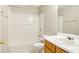 Bright bathroom features a shower-tub combo and a wood vanity with a white countertop sink at 1624 River Main Ct, Lawrenceville, GA 30046