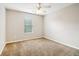 Neutral bedroom showcasing carpeted floors, a ceiling fan, and a sunlit window at 1624 River Main Ct, Lawrenceville, GA 30046