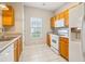 Well-lit kitchen with white appliances, wooden cabinets, and tiled floors at 1624 River Main Ct, Lawrenceville, GA 30046