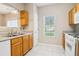 Bright kitchen featuring white appliances, wooden cabinetry and tiled floors at 1624 River Main Ct, Lawrenceville, GA 30046