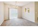 A cozy living room with carpet, a sliding glass door, and a chandelier at 1624 River Main Ct, Lawrenceville, GA 30046