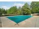 Community pool area featuring a covered pool surrounded by mature trees and blue skies at 1624 River Main Ct, Lawrenceville, GA 30046