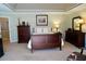 This main bedroom features a wooden bed frame, dresser, lamps, carpet, and trey ceiling at 205 Ashebourne Trl, Alpharetta, GA 30005