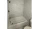 This bathroom has a pristine bathtub with tile surround, toilet, and neutral finishes at 2405 Cross Nw St, Atlanta, GA 30318